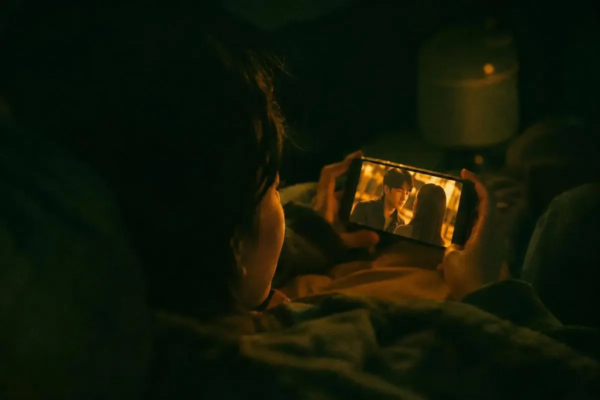夜晚用手机观看黄豆短剧短剧的场景